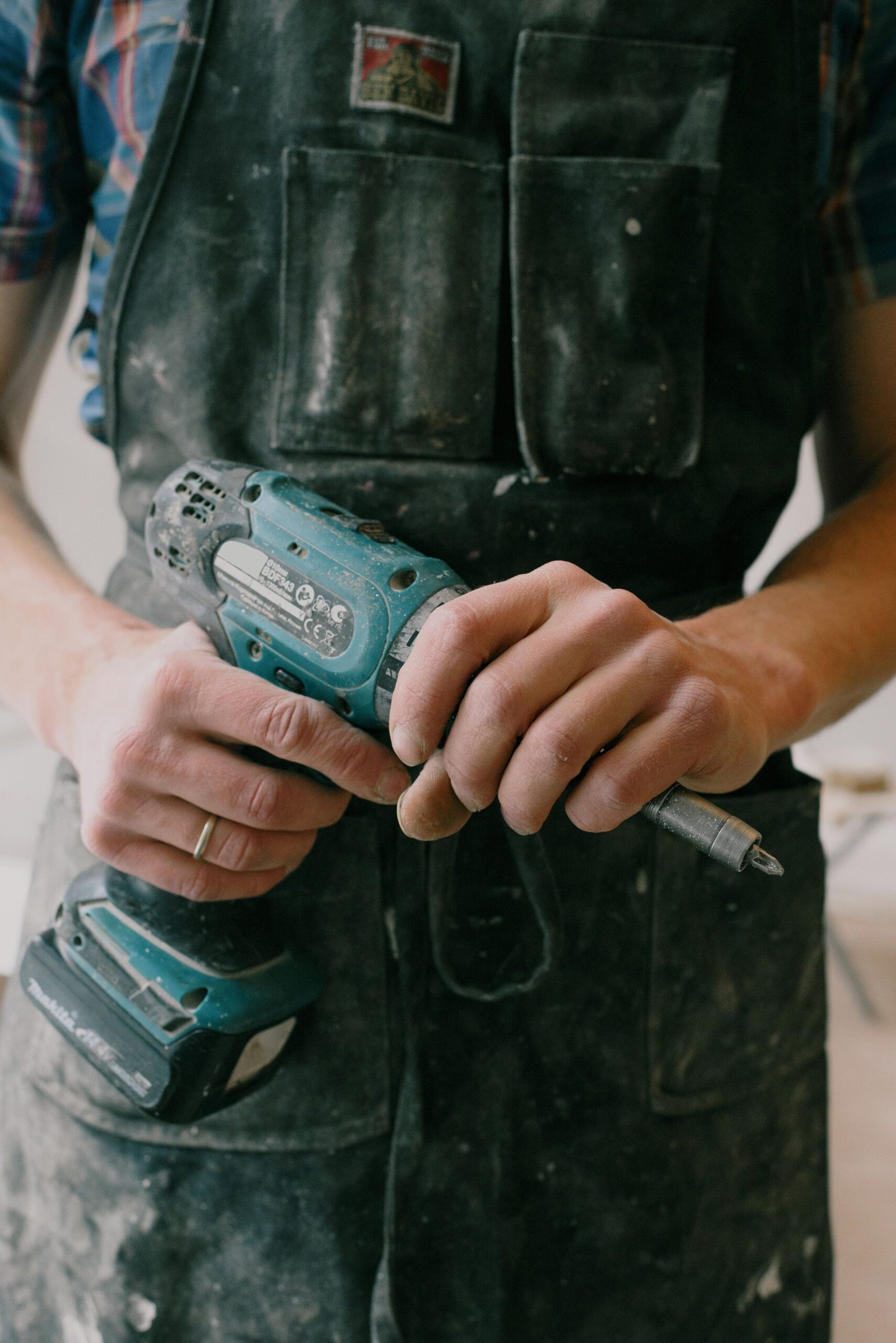 Tradesperson holding a cordless drill while working on a home job — ARM Builds Manchester