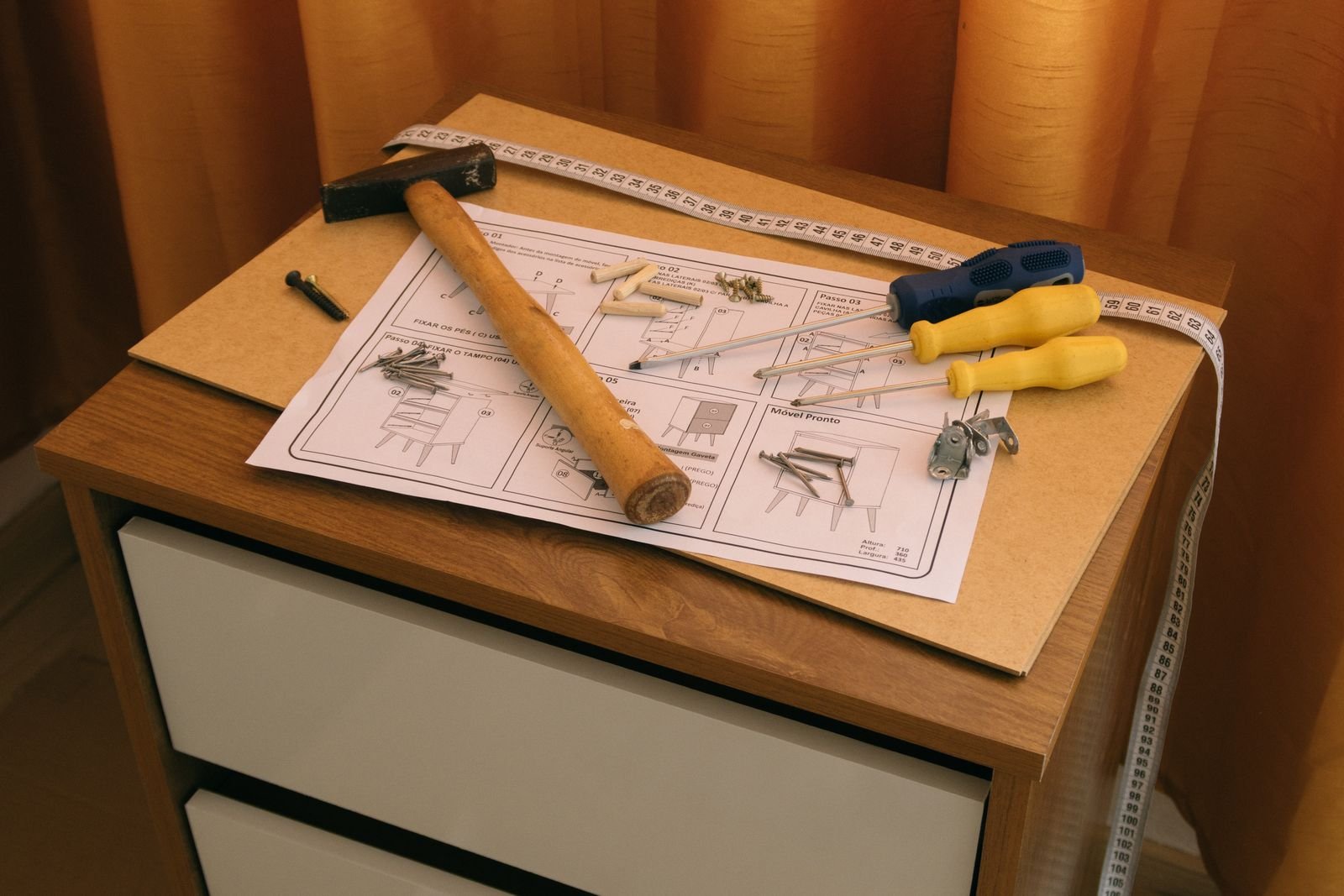 Flat-pack furniture assembly tools, screws and instructions laid out on a chest of drawers — ARM Builds Manchester