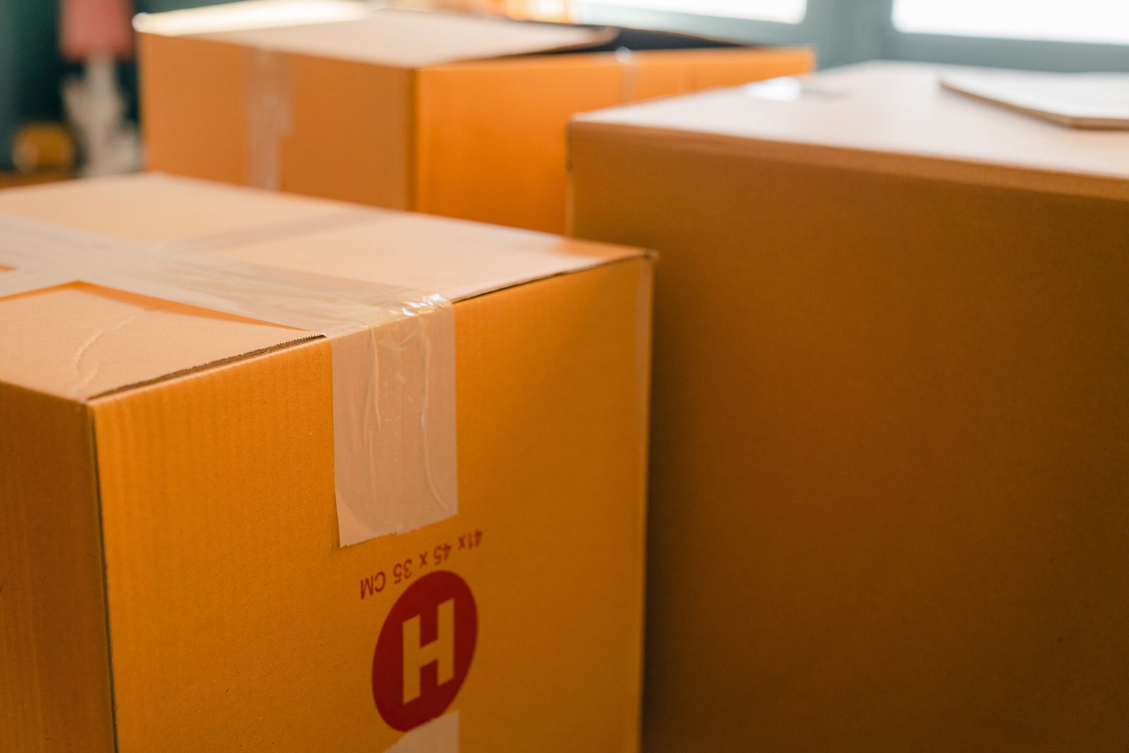 Taped cardboard moving boxes ready for a home removal — ARM Builds Manchester