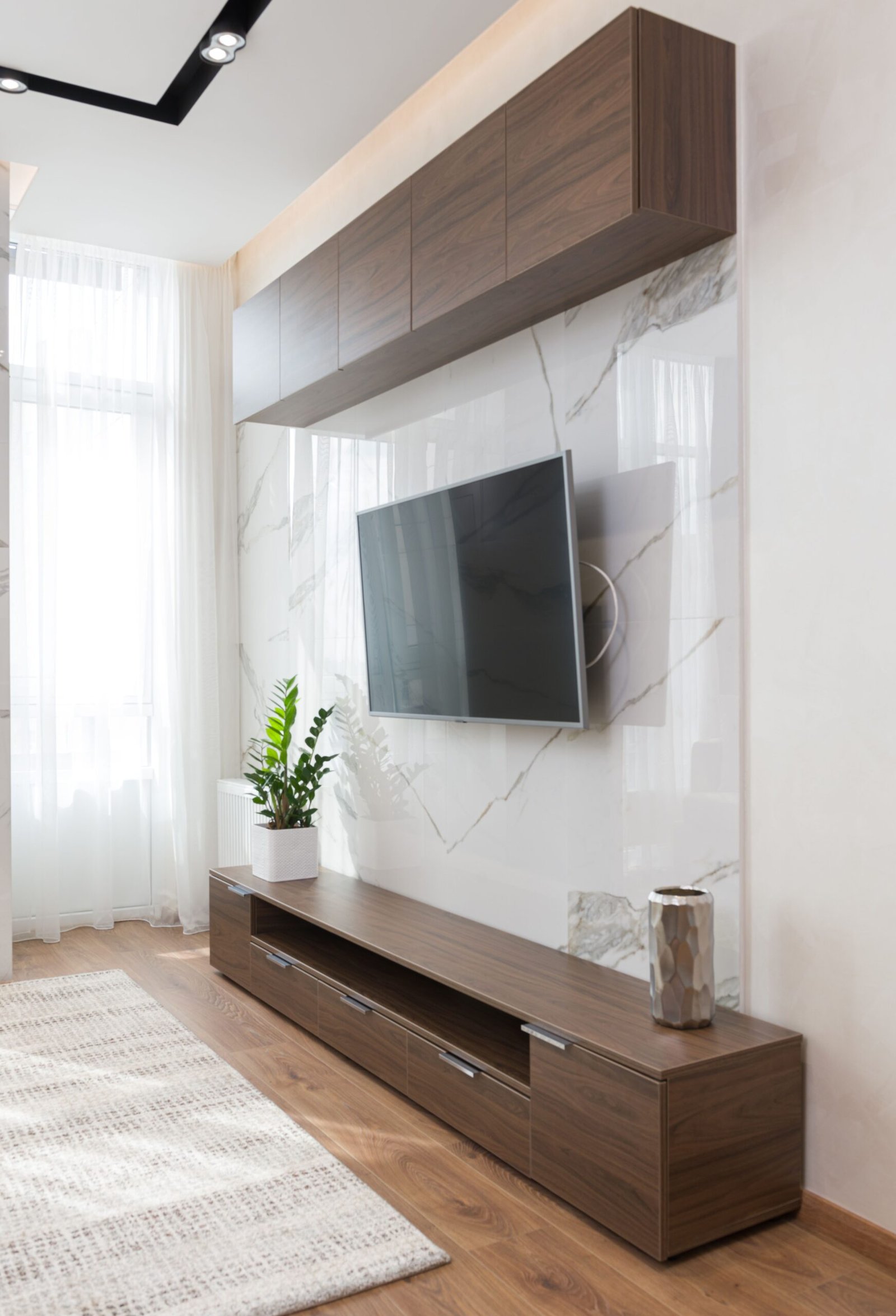 Built-in TV and storage media wall with a marble feature panel in a modern living room — ARM Builds Manchester